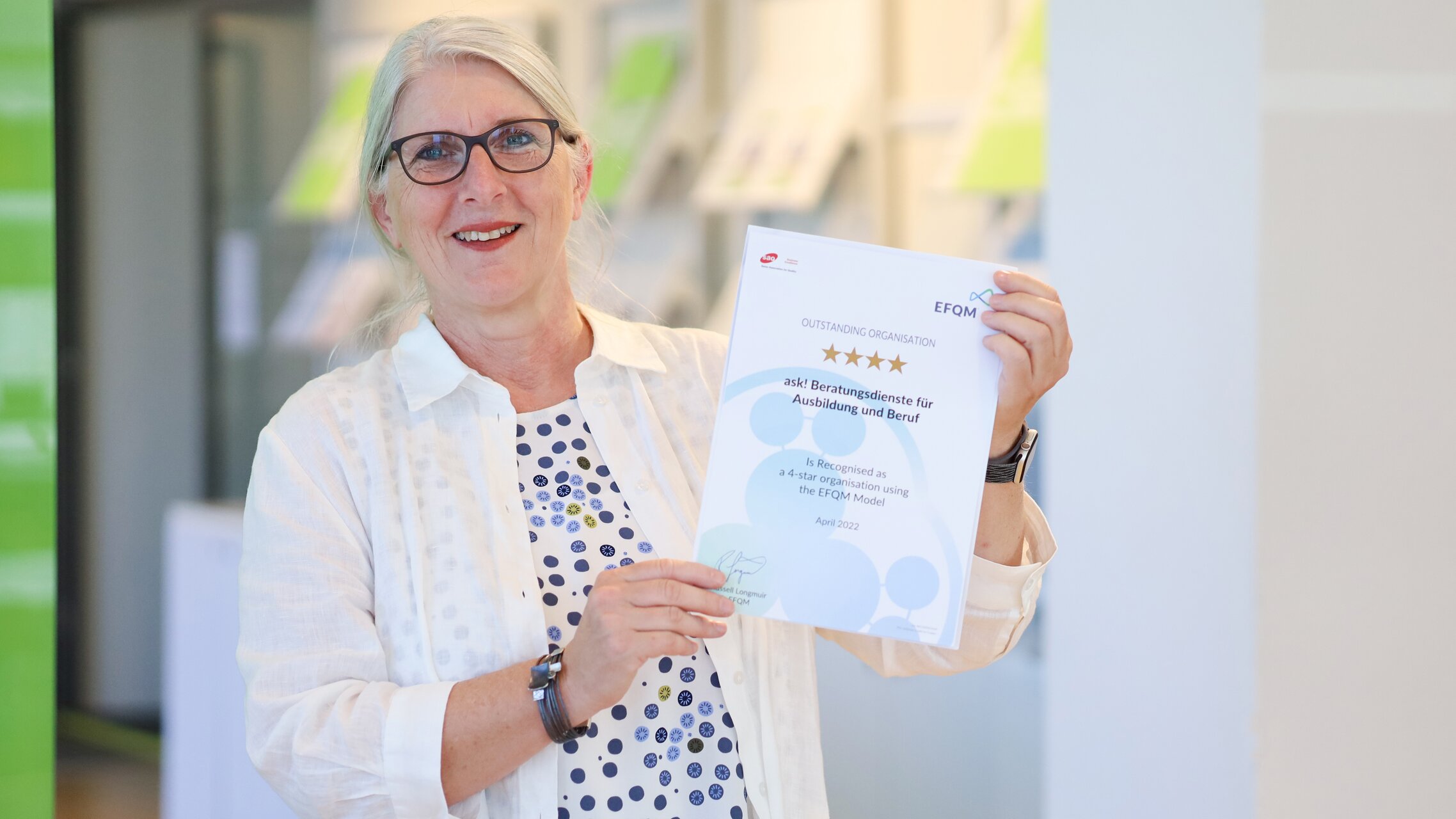 Sonja Brönnimann hält das EFQM-Zertifikat in der Hand. | © ask! - Beratungsdienste für Ausbildung und Beruf